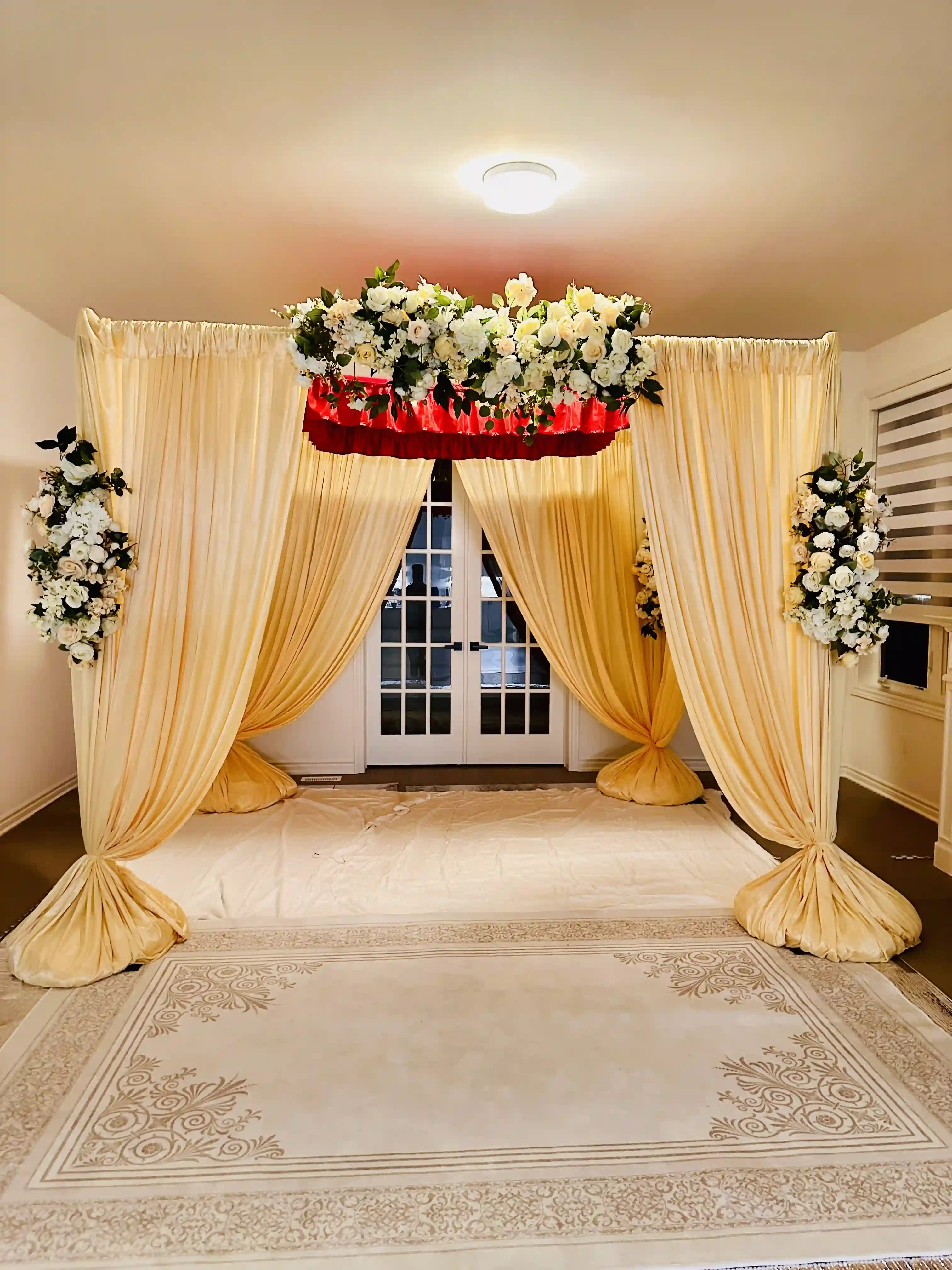 Gold and ivory draped Akand Path with white floral crown and side flower arrangements